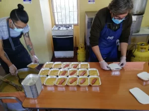 Esteban y Felipe preparando raciones de almuerzos para los vecinos